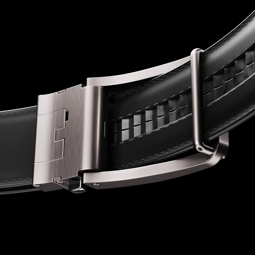 Black vegan leather ratchet belt from FJØRNA, adjustable unisex belt with a sleek design and metal buckle on a black background.