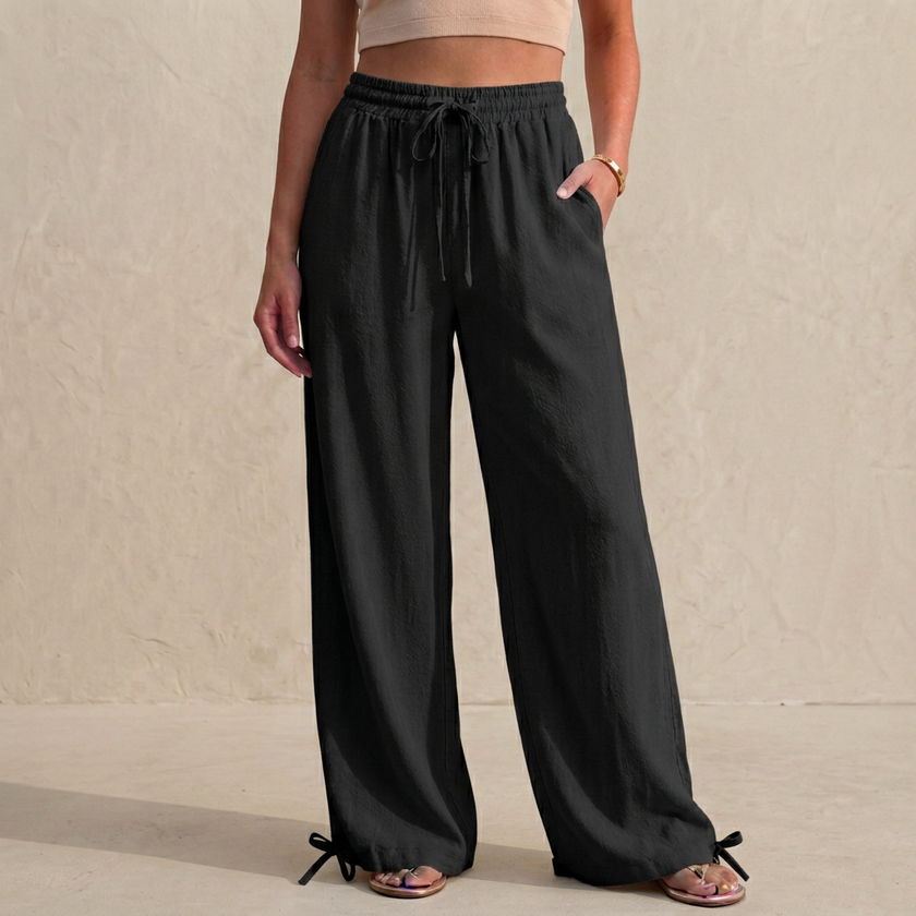 Black women's summer linen trousers with pockets and drawstring waist by FJØRNA, stylish and comfortable for warm weather.
