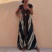 Black FJØRNA elegant maxi dress for women with geometric V-neck design and flowing silhouette.