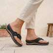 FJØRNA black orthopedic open toe wedge flip-flops with floral embellishments, featuring supportive design and stylish floral accents.