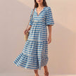 Blue FJØRNA women's elegant maxi dress with V-neck and puff sleeves, flowing fabric perfect for formal or casual occasions.