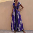 Blue FJØRNA women's elegant maxi dress with geometric V-neck, flowing fabric, and stylish design for sophisticated occasion wear.