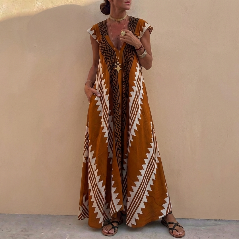 Brown FJØRNA women's elegant maxi dress with geometric V-neck, flowing fabric and stylish design perfect for formal occasions.