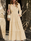 FJØRNA white V-neck pleated waist tiered long-sleeved dress displayed on a hanger, showcasing its elegant design and fabric details.