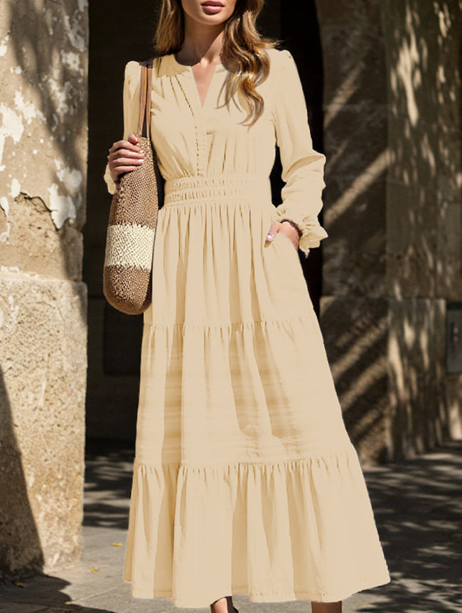 FJØRNA white V-neck pleated waist tiered long-sleeved dress displayed on a hanger, showcasing its elegant design and fabric details.