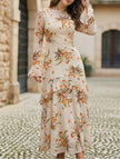 Women's white dress by FJØRNA with lotus leaf sleeves and floral print, showcasing elegant design and fabric details.