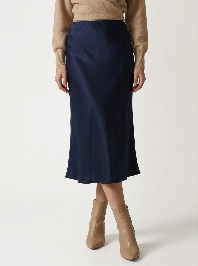 FJØRNA satin high-waist flowing midi skirt for women, elegant pencil style in smooth satin fabric, shown in a stylish shot.