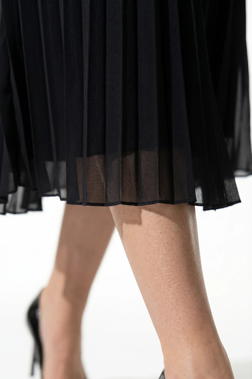 Elegant black floral lace pleated A-line maxi dress by FJØRNA, perfect for wedding guest attire, shown in a detailed macro image.