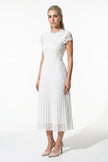 White floral lace pleated A-line maxi dress by FJØRNA, full-body view, perfect for wedding guests and summer occasions.