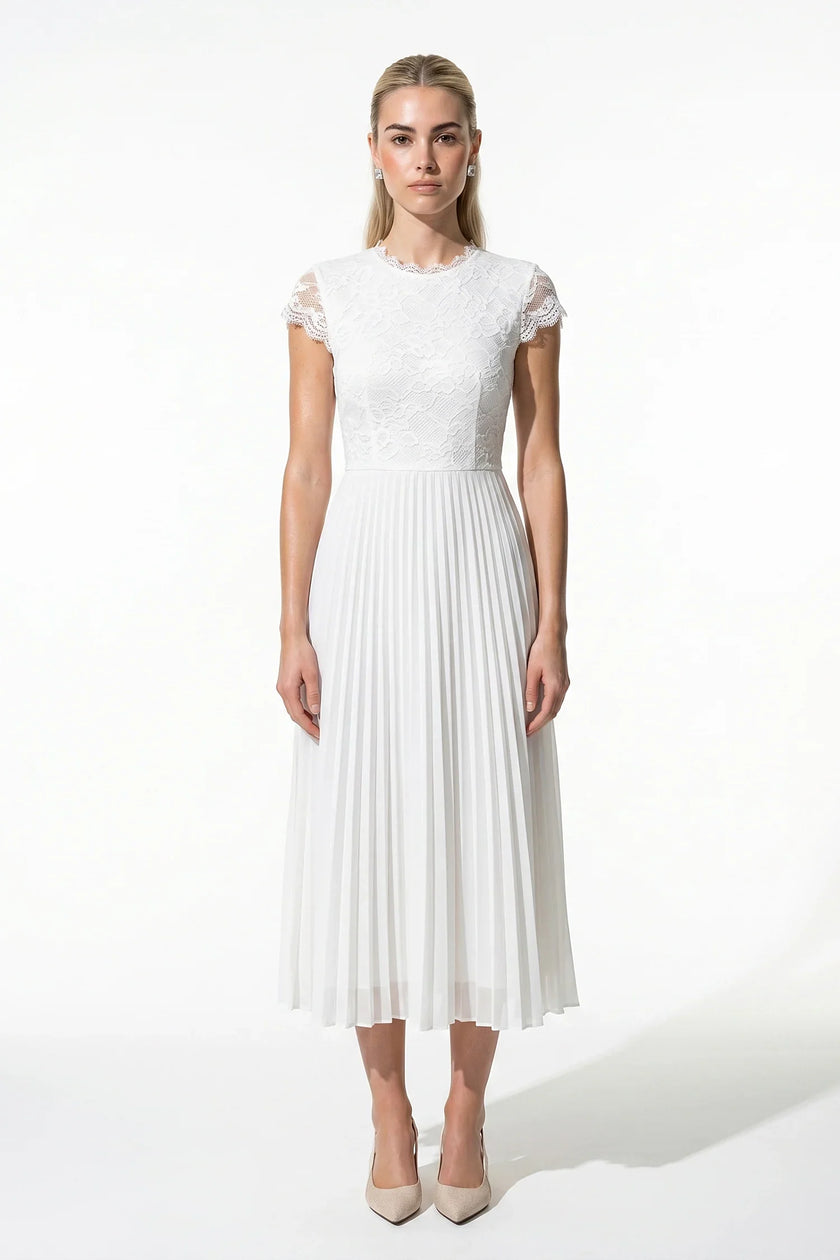 White floral lace pleated A-line maxi dress by FJØRNA, elegant wedding guest dress with flowing fabric and intricate lace details.
