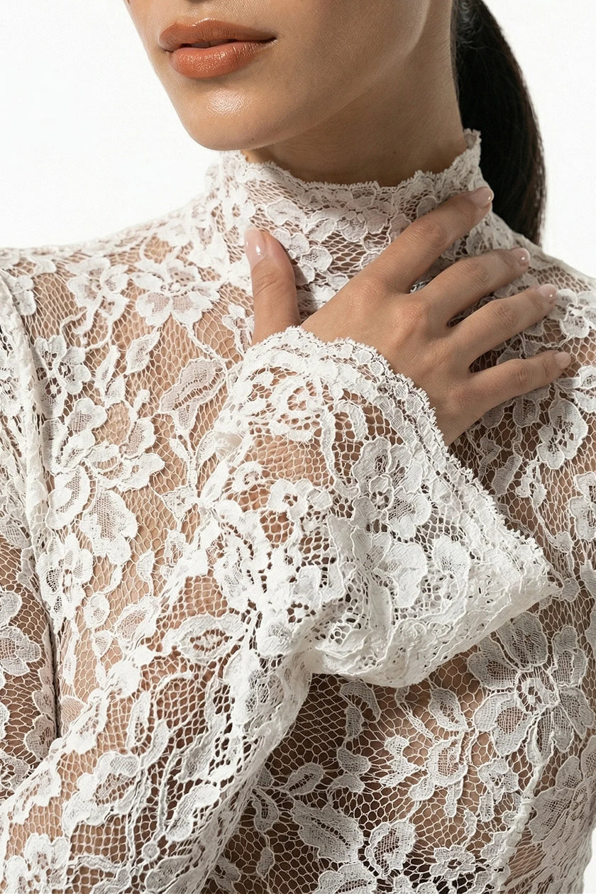 White lace midi dress for women with long sleeves, fitted style by FJØRNA, shown in a close-up macro image.