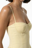 FJØRNA butter yellow sleeveless pleated halter backless midi dress for women, elegant occasion dress on a model.