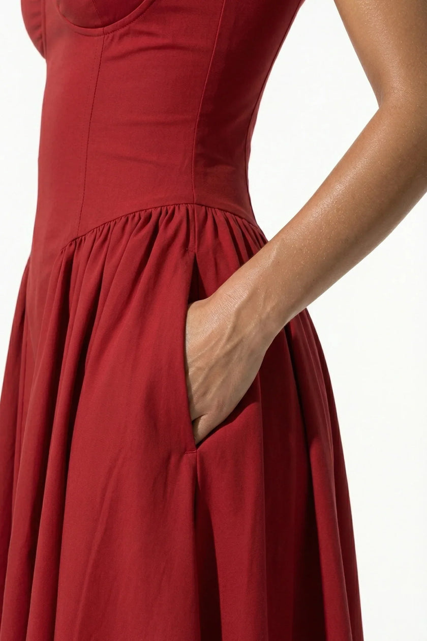 Red FJØRNA sleeveless pleated backless midi dress with halter neckline, perfect for occasions, shown in close-up detail.