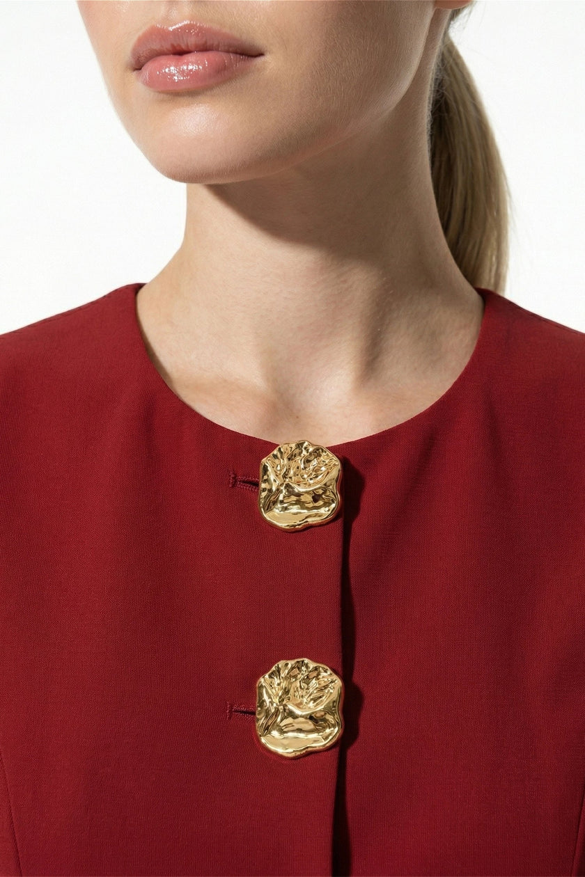 Deep red women's sleeveless waistcoat by FJØRNA with metal buttons, featuring tailored fit and layering style.