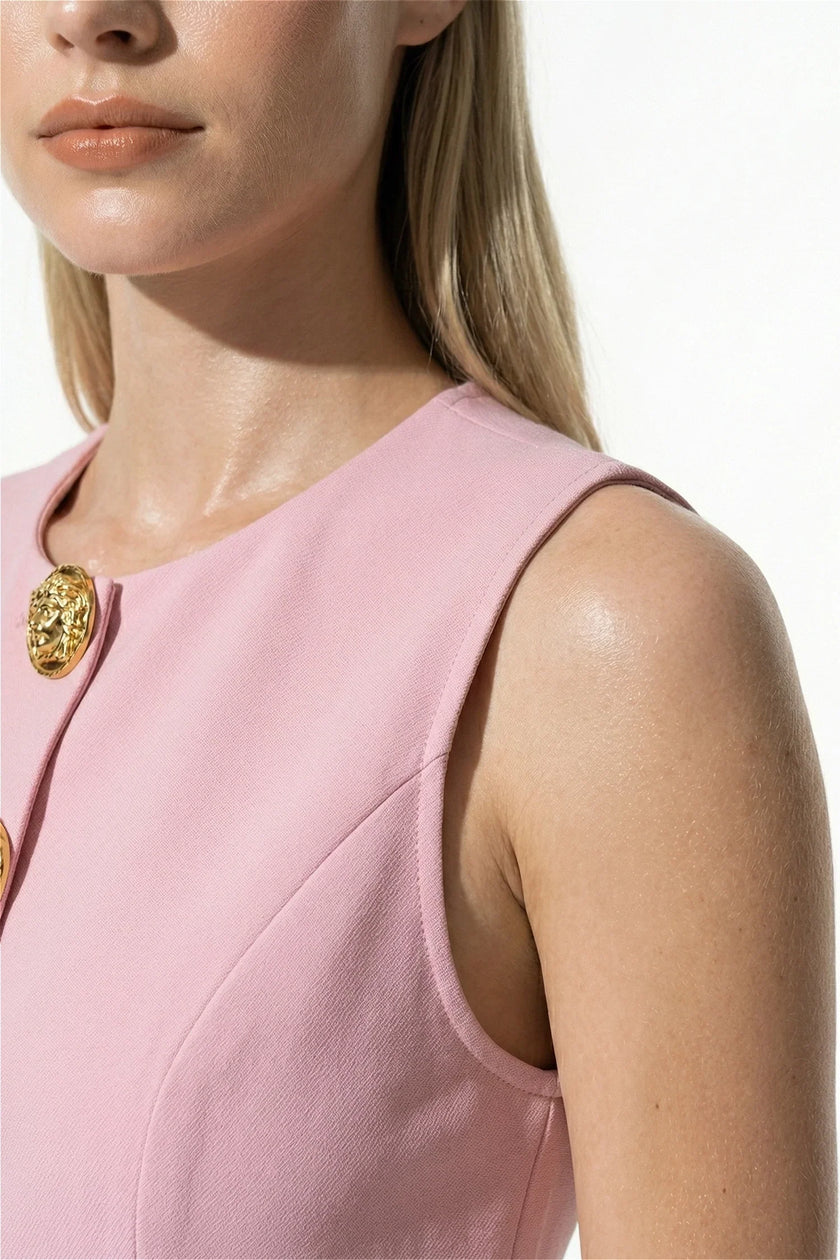 Pink tailored sleeveless women’s waistcoat with metal buttons, stylish layering piece by FJØRNA, close-up detail shot.