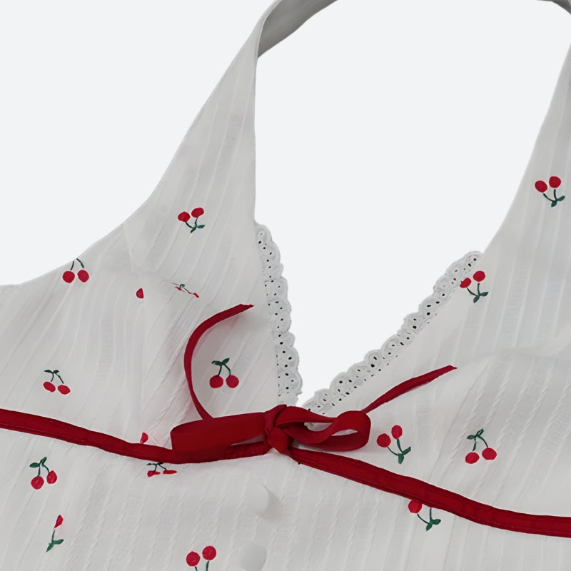 FJØRNA Coquette Cherry halter neck mini dress with playful cherry print, perfect for party and daytime wear.