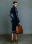 Dark blue velvet V-neck midi dress by FJØRNA, elegant evening dress with a fitted waist and flowing skirt, front view.