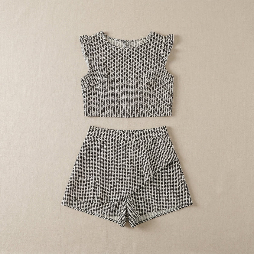 FJØRNA women's summer two-piece set with geometric ruffle design, flat lay showing top and matching skirt in vibrant fabric.