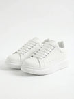 White lace-up men's trainers by FJØRNA, minimalist design, perfect for everyday casual wear, front view of the shoes.