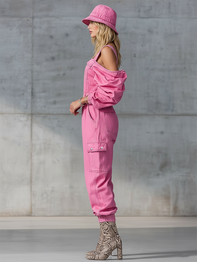 Pink denim strappy tapered long sleeve jumpsuit for women by FJØRNA, featuring a fitted design with stylish straps and long sleeves.