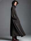 Brown knit maxi dress for women by FJØRNA, featuring a flowing silhouette and long sleeves, perfect for casual or elegant wear.
