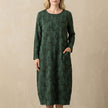 Green FJØRNA elegant maxi dress for women with long sleeves and pockets, showcasing a flowing silhouette and stylish design.