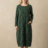 Green FJØRNA elegant maxi dress for women with long sleeves and pockets, showcasing a flowing silhouette and stylish design.