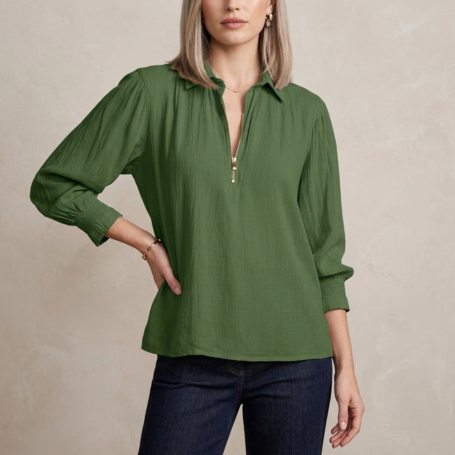 Green FJØRNA summer blouse for women with long sleeves and smocked design, shown on a model.