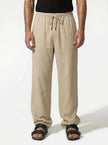 Men's linen trousers by FJØRNA, relaxed fit, breathable summer pants shown in a half-shot focusing on fabric and design.