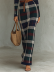 FJØRNA women's knit maxi dress displayed on a model, featuring a flowing silhouette and long sleeves in soft knit fabric.