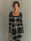 FJØRNA women's knit maxi dress featuring a flowing silhouette and long sleeves, styled with a V-neck and ribbed texture.