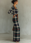 FJØRNA knit maxi dress for women, full-length with long sleeves and a fitted waist, displayed on a hanger against a white background.
