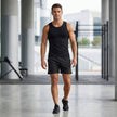 Men's FJØRNA athletic shorts with elastic waist and side slits, shown in a relaxed lifestyle setting.