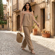 FJØRNA women's summer two-piece set with wide-leg pants, lightweight fabric, and matching top, styled in a casual outdoor setting.