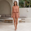 FJØRNA summer two-piece women's co-ord set with pleated design, shown worn casually in a lifestyle setting.