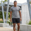 Men's FJØRNA adjustable-waist woven athletic shorts with pockets, shown in a casual lifestyle setting.