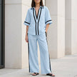 Light blue FJØRNA women's two-piece co-ord set with wide-leg pants and V-neck top, showcasing elegant casual style.