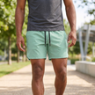 Light green men's woven athletic shorts with adjustable waist and pockets, designed for active wear by FJØRNA.