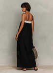 FJØRNA linen strapless maxi evening dress displayed on a hanger, featuring flowing fabric and elegant design.