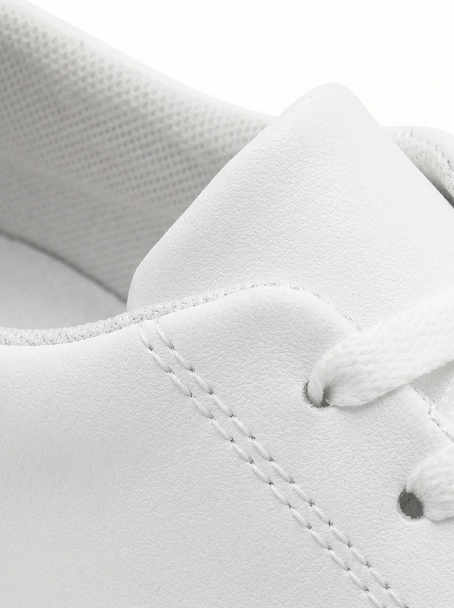 Close-up of men's white slip-on trainers by FJØRNA, showcasing minimalist design and clean casual style.