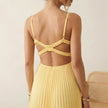 FJØRNA elegant women's maxi dress with V-neck, sleeveless design and pleated fabric on a model.