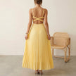 FJØRNA elegant sleeveless maxi dress with V-neck and pleated design worn by a model, perfect for stylish occasions.