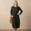 FJØRNA elegant women's maxi dress with long sleeves and pockets, modeled on woman showcasing flowy fabric and stylish design.