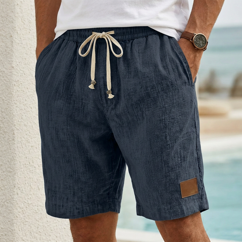 Navy blue men's casual drawstring shorts by FJØRNA with pockets and elegant accents, suitable for everyday wear.