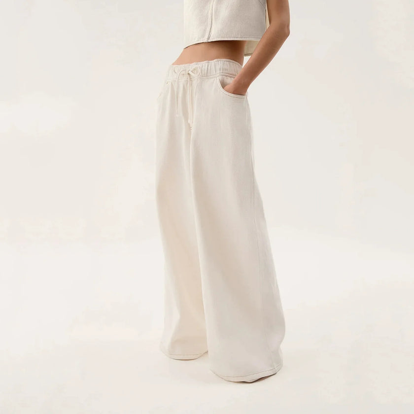 Blue denim wide-leg drawstring jeans for women by FJØRNA, relaxed fit pants with a casual style and comfortable waistband.