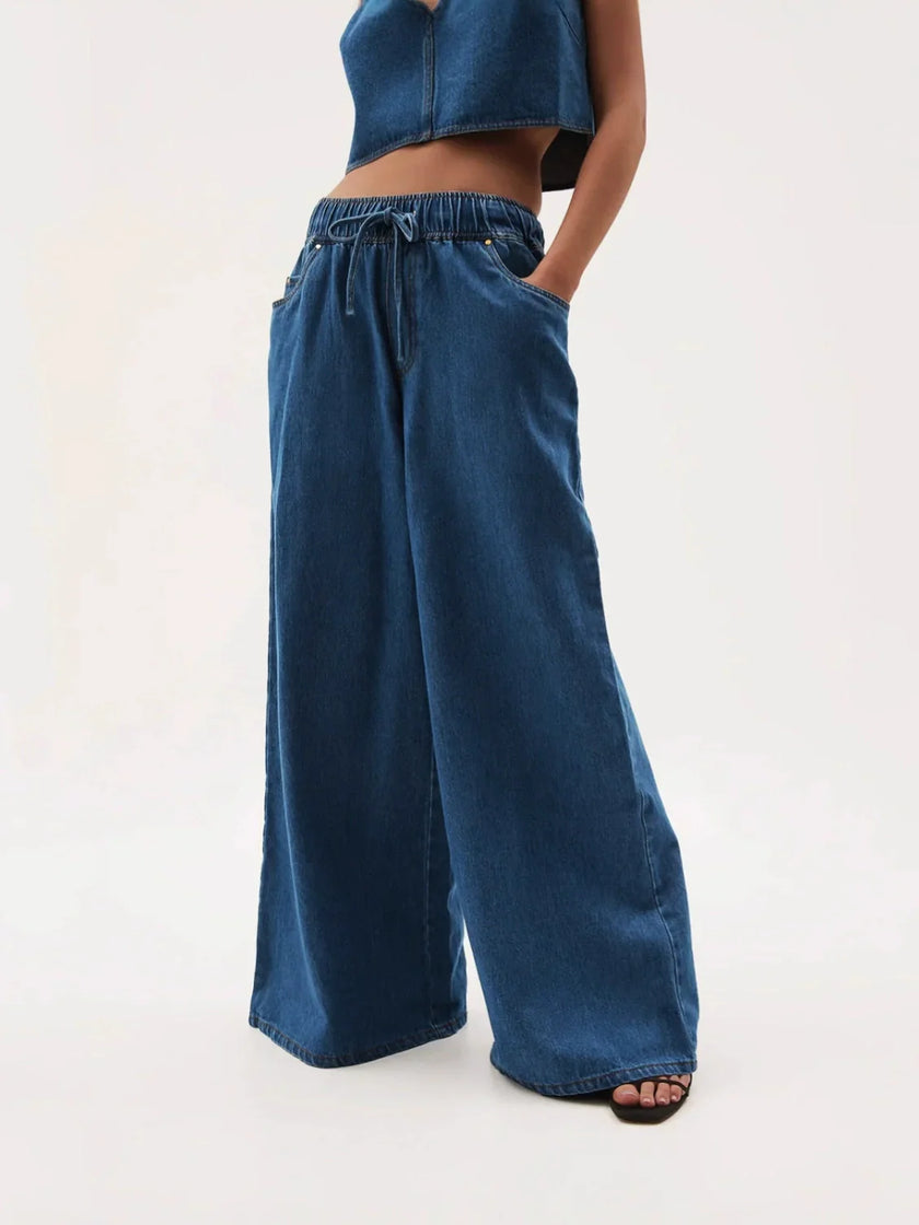 Blue denim wide-leg drawstring jeans for women by FJØRNA, featuring a relaxed fit and casual style.