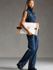Dark blue denim sleeveless jumpsuit with multi-pocket design and balloon pants style, by FJØRNA, shown on a model.