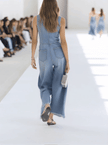 Light blue denim sleeveless raw edge wide-leg jumpsuit for women by FJØRNA, shown with a relaxed fit and stylish design.