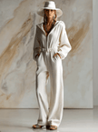 White corduroy hooded zip-front long sleeve jumpsuit for women, featuring a relaxed fit and stylish design by FJØRNA.
