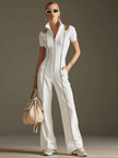 White cotton blend wide-leg jumpsuit with short sleeves, women's FJØRNA pants featuring a relaxed fit and modern style.
